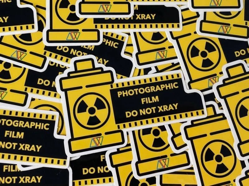 A pile of yellow film-canister stickers that read 