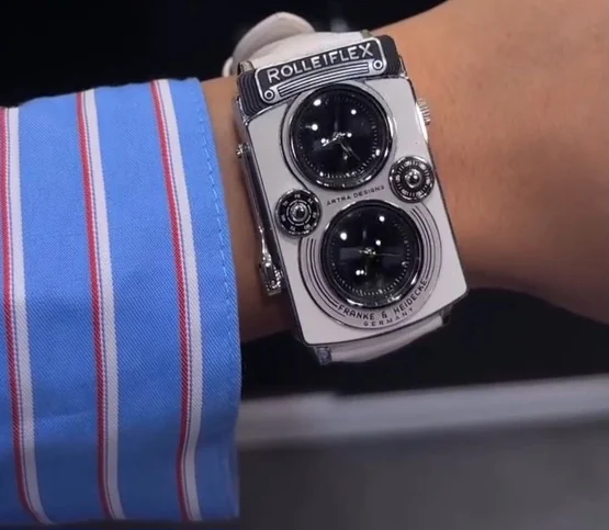 손목에 찬 CAMERA DUAL ROLLEIFLEX. 은색 케이스가 손목 폭을 거의 채우고 있다