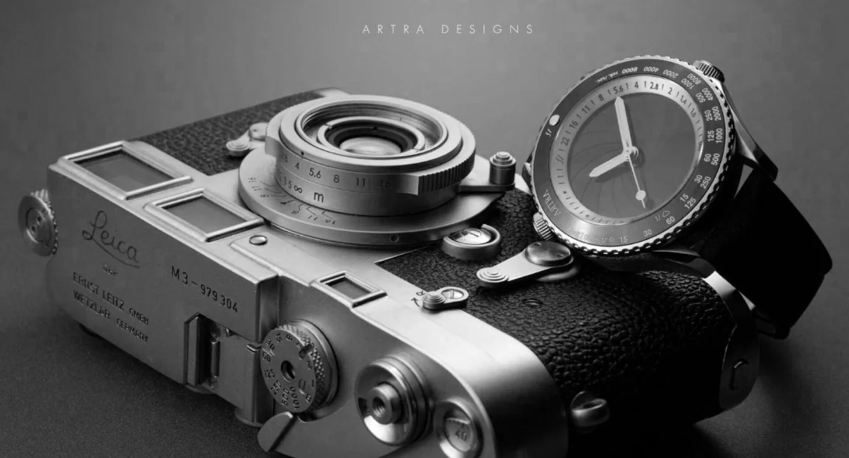モノクロ写真。ライカM3の横にシルバーケースのCamera Oneが立てかけられている