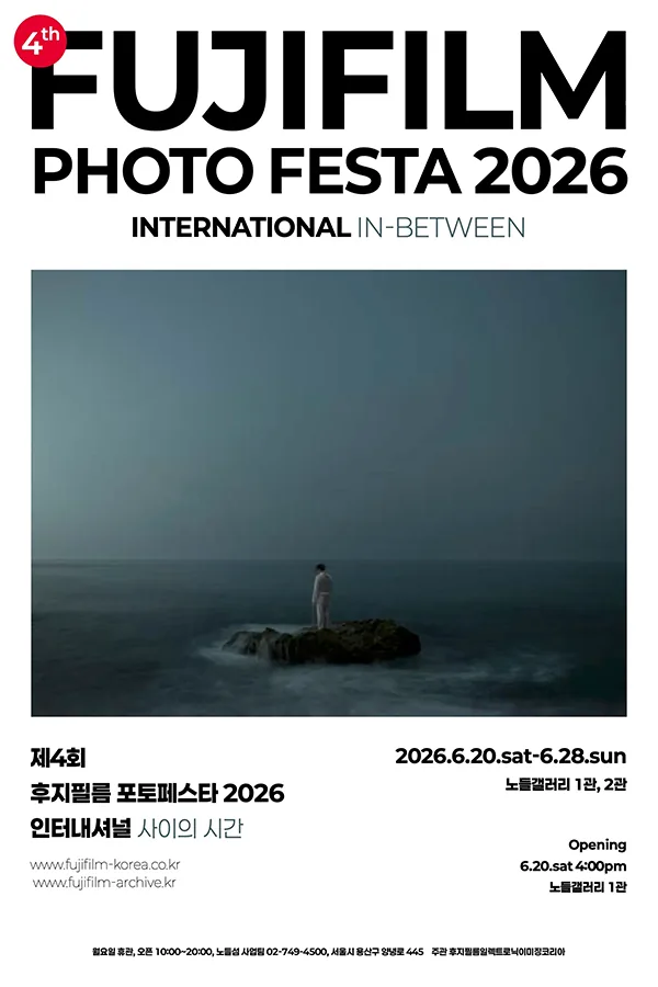 제4회 후지필름 포토페스타 2026 인터내셔널 IN-BETWEEN 포스터. 어둑한 청회색 톤의 바다 위 작은 바위에 흰 옷을 입은 사람이 등을 보이고 앉아 있는 사진이 중앙에 놓여 있고, 상단에 FUJIFILM PHOTO FESTA 2026 INTERNATIONAL IN-BETWEEN 큰 타이포, 하단에 일정·장소 정보가 정렬되어 있다.
