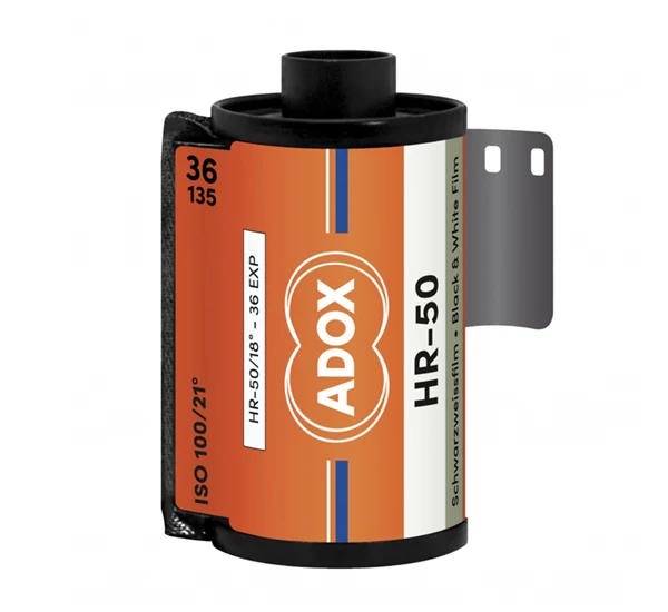 ADOX HR-50 필름 카세트. 주황색과 은색 라벨에 ADOX HR-50, Schwarzweissfilm · Black & White Film, 36 · 135 라고 적혀 있다.