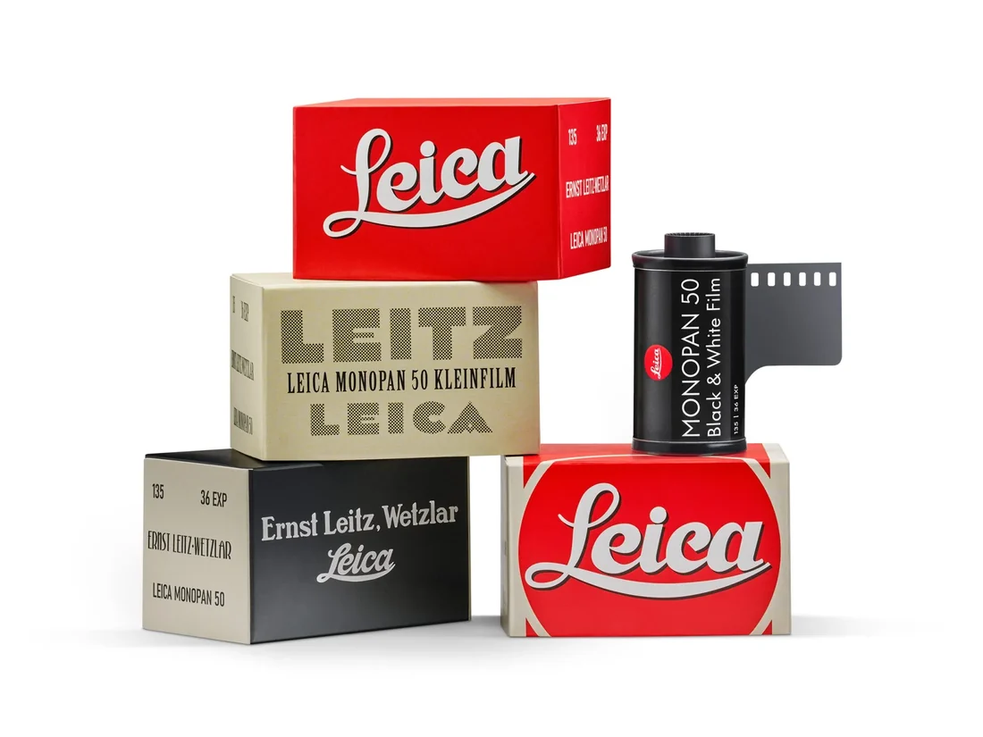Leica Monopan 50 패키징. 붉은색 Leica 필기체, 크림색 LEITZ · LEICA MONOPAN 50 KLEINFILM, 검정색 Ernst Leitz Wetzlar 등 빈티지 스타일 4종 상자가 쌓여 있고, 그 옆에 붉은 라이카 점이 박힌 검은 MONOPAN 50 Black & White Film 카세트가 필름 리더를 물고 서 있다.