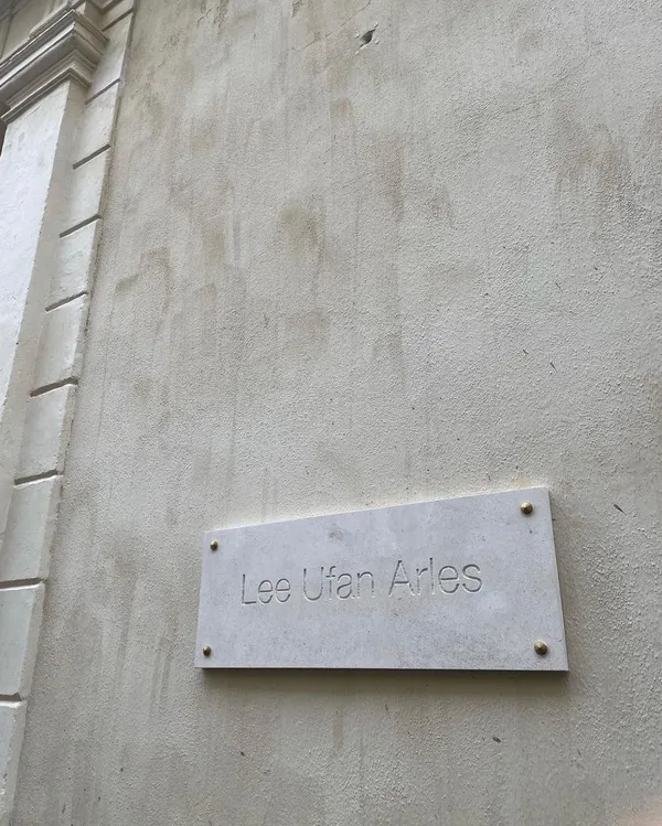 빛바랜 석회벽에 붙은 Lee Ufan Arles 석판 현판.