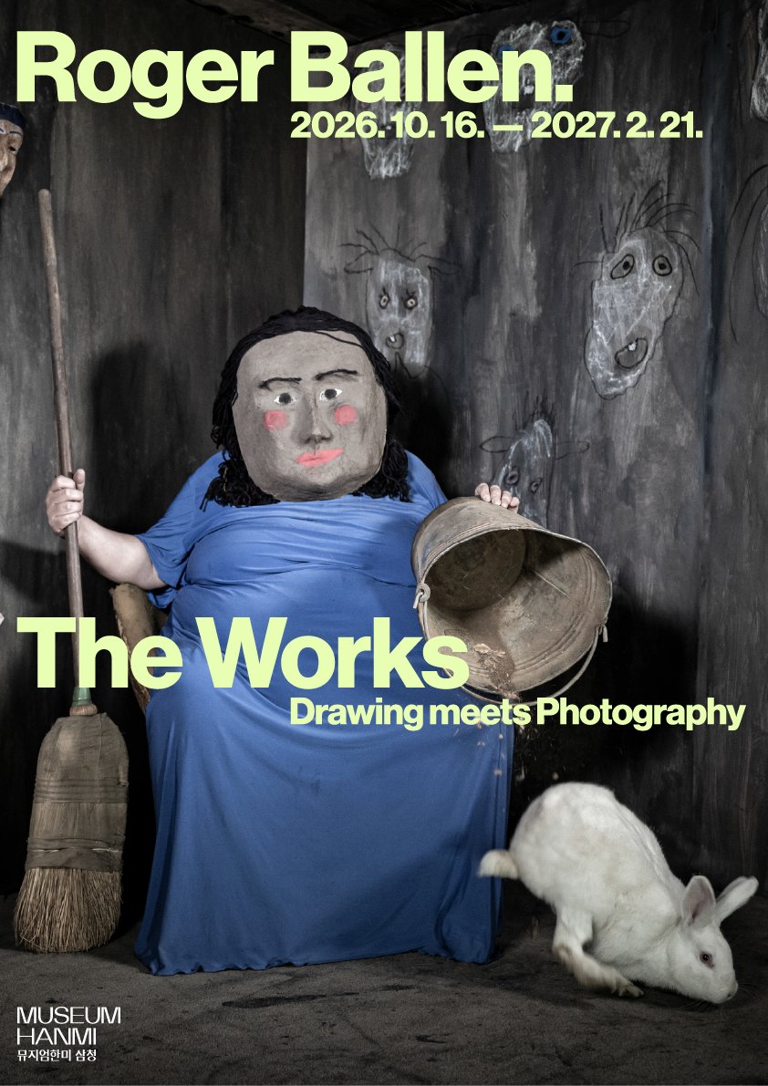 ロジャー・バレン《The Works: Drawing meets Photography》展のポスター。青いワンピースに仮面をつけた人物と白いウサギの写真の上に、展覧会名と2026.10.16.–2027.2.21.の会期が書かれている。