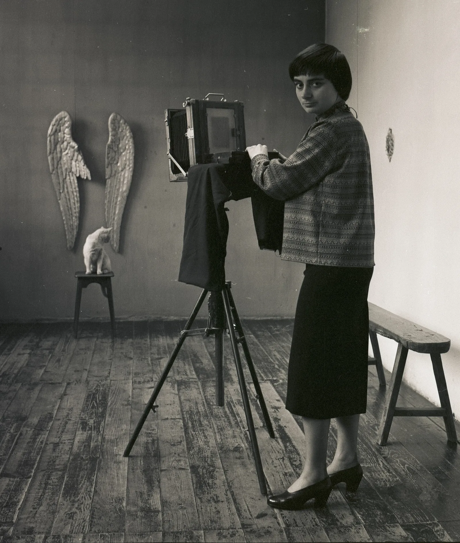 1956年、パリのダゲール通りの仕事場で大型カメラの横に立つヴァルダの自画像。